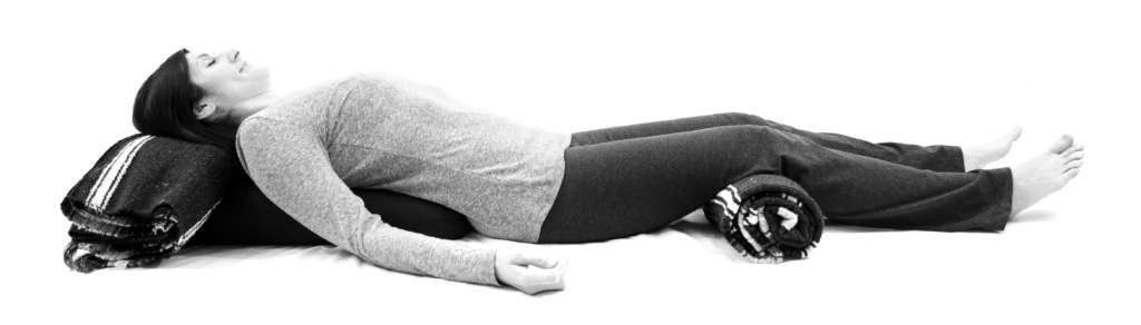 Supported Reclining Pose - arms out, blanket roll - from Yoga for Low Back and Hip Health